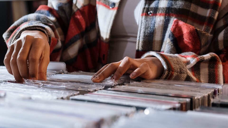 Hands browsing through a row of archived records