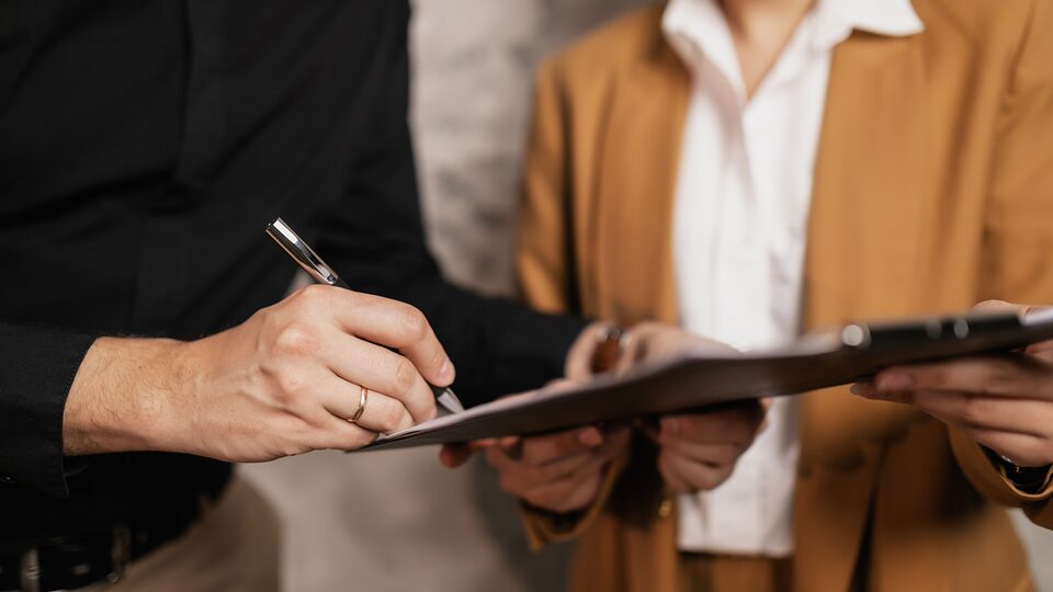 Two professionals reviewing and signing a document