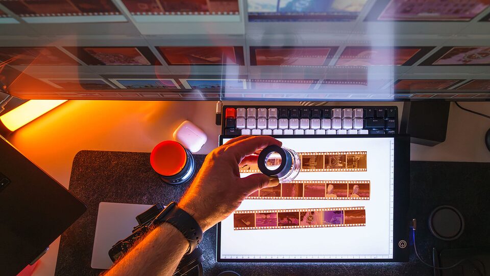 Film negatives examined with a loupe on a light table